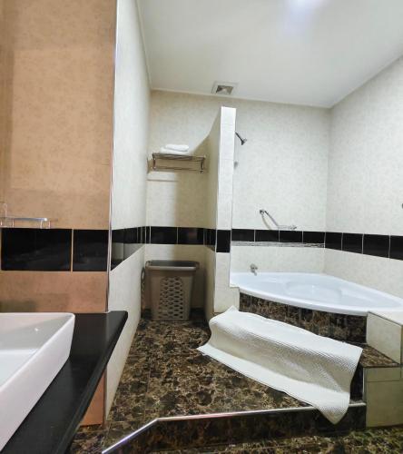a bathroom with two sinks and a bath tub at Annavilla7 Lilongwe hotel in Lilongwe
