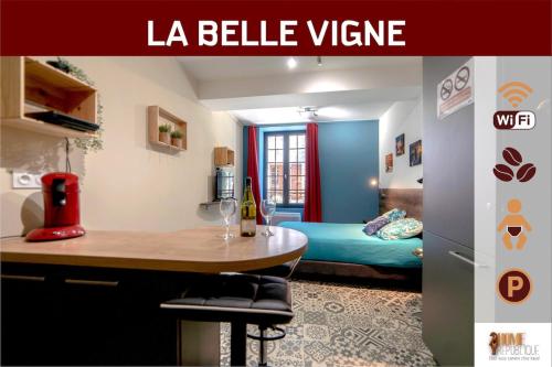 a room with a table and a bed in a room at La Belle vigne - Chablis Centre in Chablis