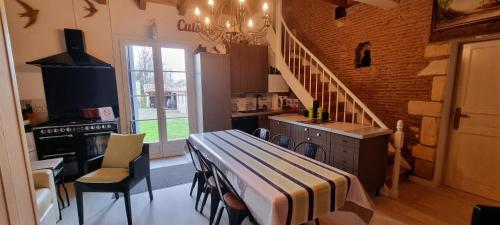 - une cuisine avec une table et un escalier dans une chambre dans l'établissement chartreuse st Cernin, à Bergerac