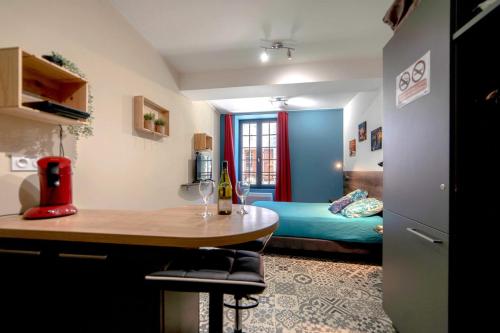 a room with a bed and a table in a room at La Belle vigne - Chablis Centre in Chablis