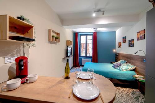 a living room with a table and a bed at La Belle vigne - Chablis Centre in Chablis