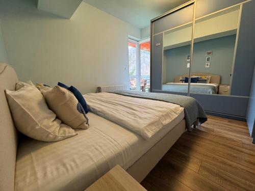 a bedroom with a large bed with a large mirror at 4 Seasons Apartment Sinaia in Sinaia