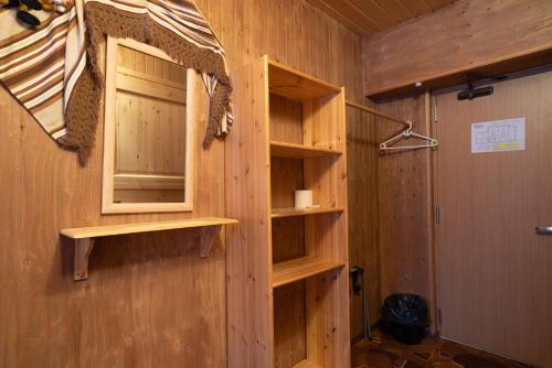 a room with wooden walls with shelves and a window at Nelijärve Holiday Centre in Aegviidu