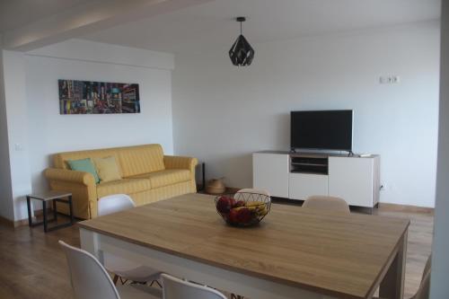 a living room with a table with a bowl of fruit on it at Casa do Largo in Faro