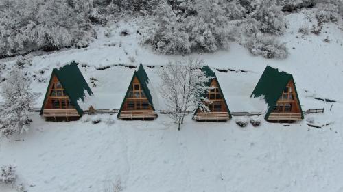 a group of cottages in the snow at Sunčani Brijeg Eco Village in Plav