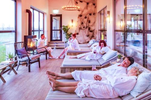 a group of people laying in beds in a room at Hotell Mossbylund in Abbekås