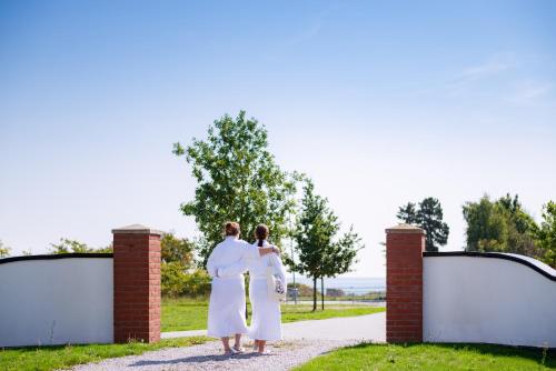 a man and a woman standing in front of a gate at Hotell Mossbylund in Abbekås