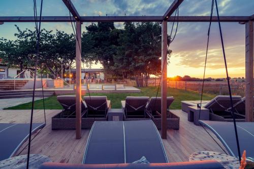 a patio with couches and a sunset in the background at Hotell Mossbylund in Abbekås
