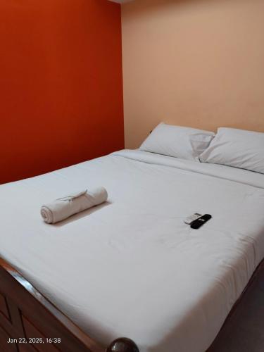 a white bed with a phone on top of it at villaa eden in Puducherry