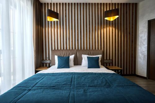 a bedroom with a large bed with blue pillows at CHALET NEBO in Bukovel