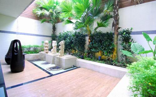a courtyard with plants and statues on a wooden floor at Yes Motel in Zhonghe