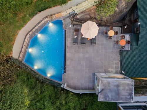 an overhead view of a swimming pool with an umbrella at Hotel Travellers Nest Kandy in Kandy