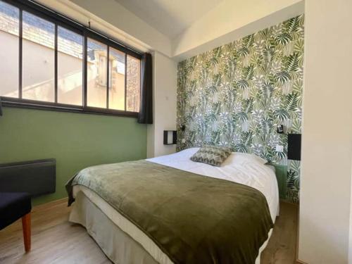 a bedroom with a bed and a large window at L'Atelier Saint-Martin by Melrose in Saint-Martin-des-Entrées