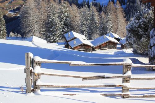 una recinzione di legno di fronte a una casa innevata di Maiensäss Stafel 45 a Mutten