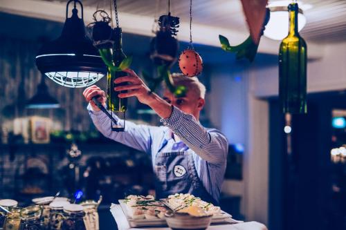 a man is holding up a plant in a room at Hotell Mossbylund in Abbekås