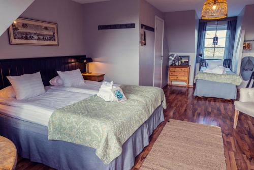 a bedroom with two beds and a chair in it at Hotell Mossbylund in Abbekås