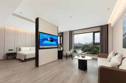 a living room with a couch and a tv at Atour Hotel Guilin Elephant Trunk Hill Sun and Moon Twin Pagodas in Guilin