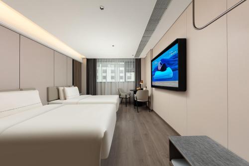 a hotel room with two beds and a flat screen tv at Atour Hotel Guilin Elephant Trunk Hill Sun and Moon Twin Pagodas in Guilin