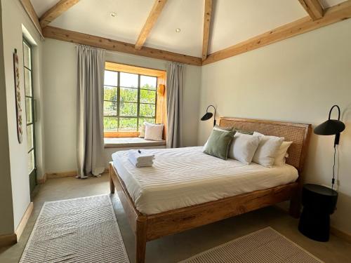 a bedroom with a bed and a window at Kilima Gardens in Nanyuki