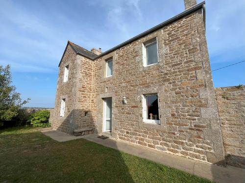 an old brick house with white windows and a yard at Maison double en pierres pour grande famille ou groupe amis in Sibiril