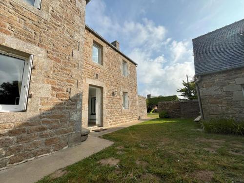 an external view of a brick building with a yard at Maison double en pierres pour grande famille ou groupe amis in Sibiril