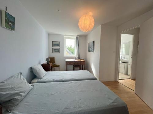 a bedroom with two beds and a light fixture at Maison double en pierres pour grande famille ou groupe amis in Sibiril