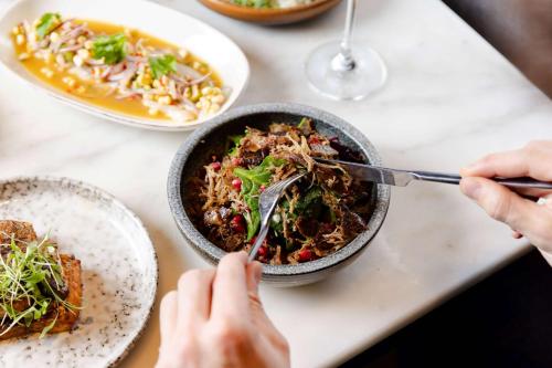 a person eating a bowl of food on a table at Radisson Blu Hotel, London Leicester Square in London