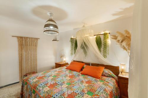 ein Schlafzimmer mit einem Bett mit orangefarbenen Kissen in der Unterkunft Casa vacacional La Finca González in Tenteniguada