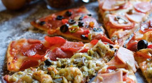 two slices of pizza sitting on top of a table at Boracay Mandarin Island Hotel in Boracay