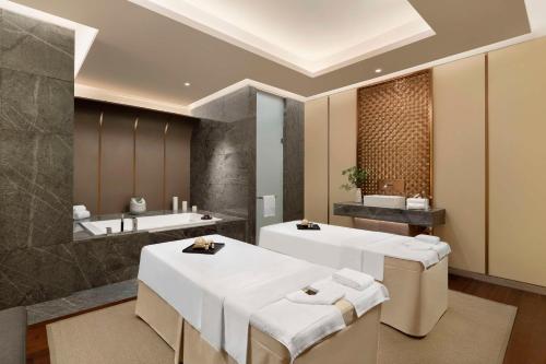 a bathroom with two sinks and a bath tub at Radisson Collection, Wuxi in Wuxi