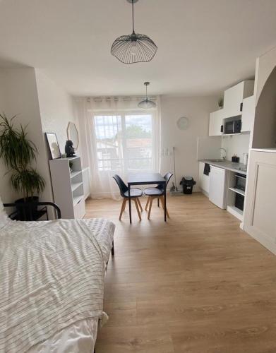 une pièce avec une table et des chaises et une cuisine dans l'établissement Appartement T1 Colomiers proche AIRBUS, à Colomiers