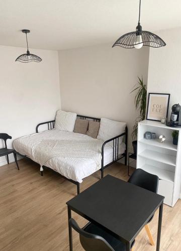 une chambre avec un lit et une table dedans dans l'établissement Appartement T1 Colomiers proche AIRBUS, à Colomiers