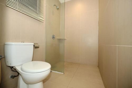 a bathroom with a toilet and a glass shower at Memoire Hornbill Hotel Kuching Sarawak in Kuching