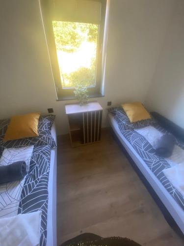 two beds in a room with a window at Szczyrkowskie Tarasy in Szczyrk