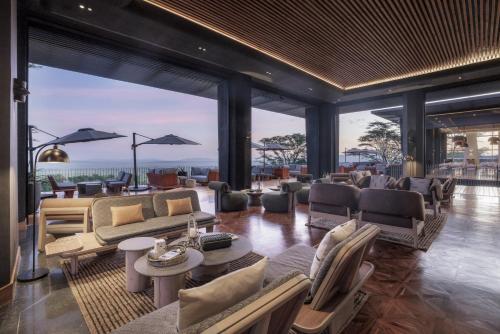 a living room with couches and tables and a large window at Serengeti Explorer in Serengeti