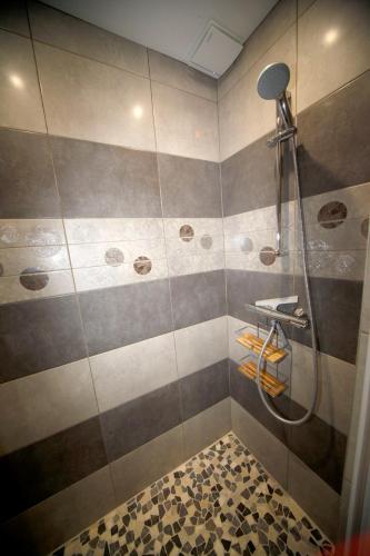 La salle de bains est pourvue d'une douche avec des rayures gris et marron. dans l'établissement Les Gîtes Champêtres Walnut cottage, à Sainteny