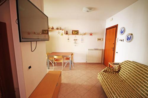 a living room with a table and a tv at Soffio di mare in Alba Adriatica