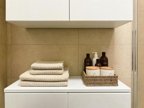a white cabinet with towels and wine bottles on it at Jako doma - centrally located apartment in Liberec