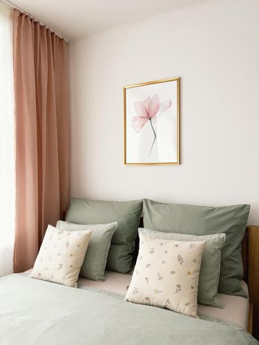 a bedroom with a bed with a pink flower on the wall at Jako doma - centrally located apartment in Liberec