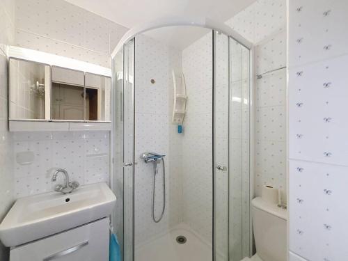une salle de bain blanche avec une douche et un lavabo dans l'établissement Duplex en front de mer avec balcon à Merville-Franceville-Plage - FR-1-465-99, à Merville-Franceville-Plage