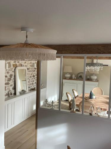 a dining room with a table and a mirror at Maison Charmille in Féricy