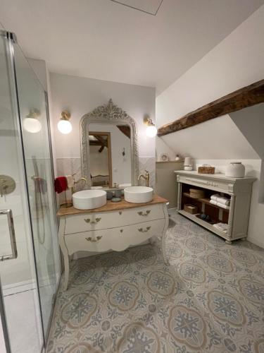 une salle de bain avec deux lavabos et un miroir dans l'établissement Maison Charmille, à Féricy