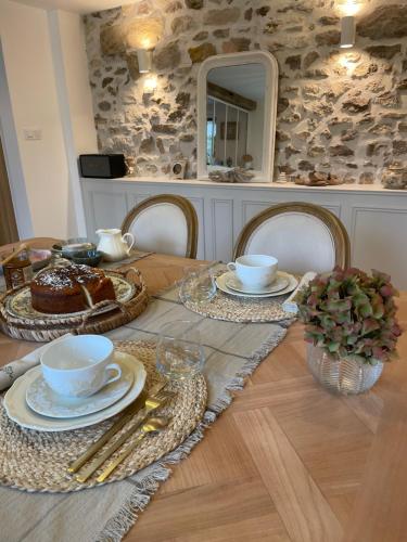 een tafel met cake en bekers en borden erop bij Maison Charmille in Féricy