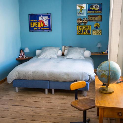 a bedroom with a bed and a blue wall at B&B Chez tante Alice in Durbuy