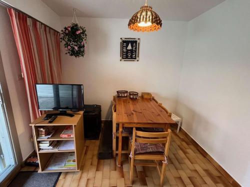 une salle à manger avec une table en bois et une télévision dans l'établissement Charmant T3 familial - Front de mer, terrasse, parking, proche plage et activités, tout confort - FR-1-607-199, au Cap d'Agde
