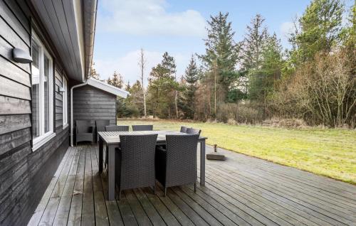 a deck with a table and chairs on a house at Cozy Home In Jerup With Wifi in Jerup