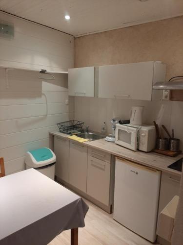 une cuisine avec un évier et un micro-ondes dans l'établissement L oustau des Arênes, à Arles