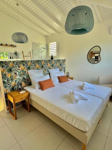 a bedroom with a large bed with towels on it at Villa Cokoon in Saint-François