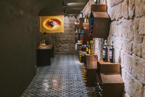 a corridor of a wine tasting room with a wall of wine bottles at Atelier Inès Arts & Suites in Naples