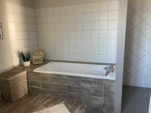 a bath tub in a bathroom with a tile wall at ღ Le Somptueux Spatieux, Jardin,Proche Plage in La Couarde-sur-Mer